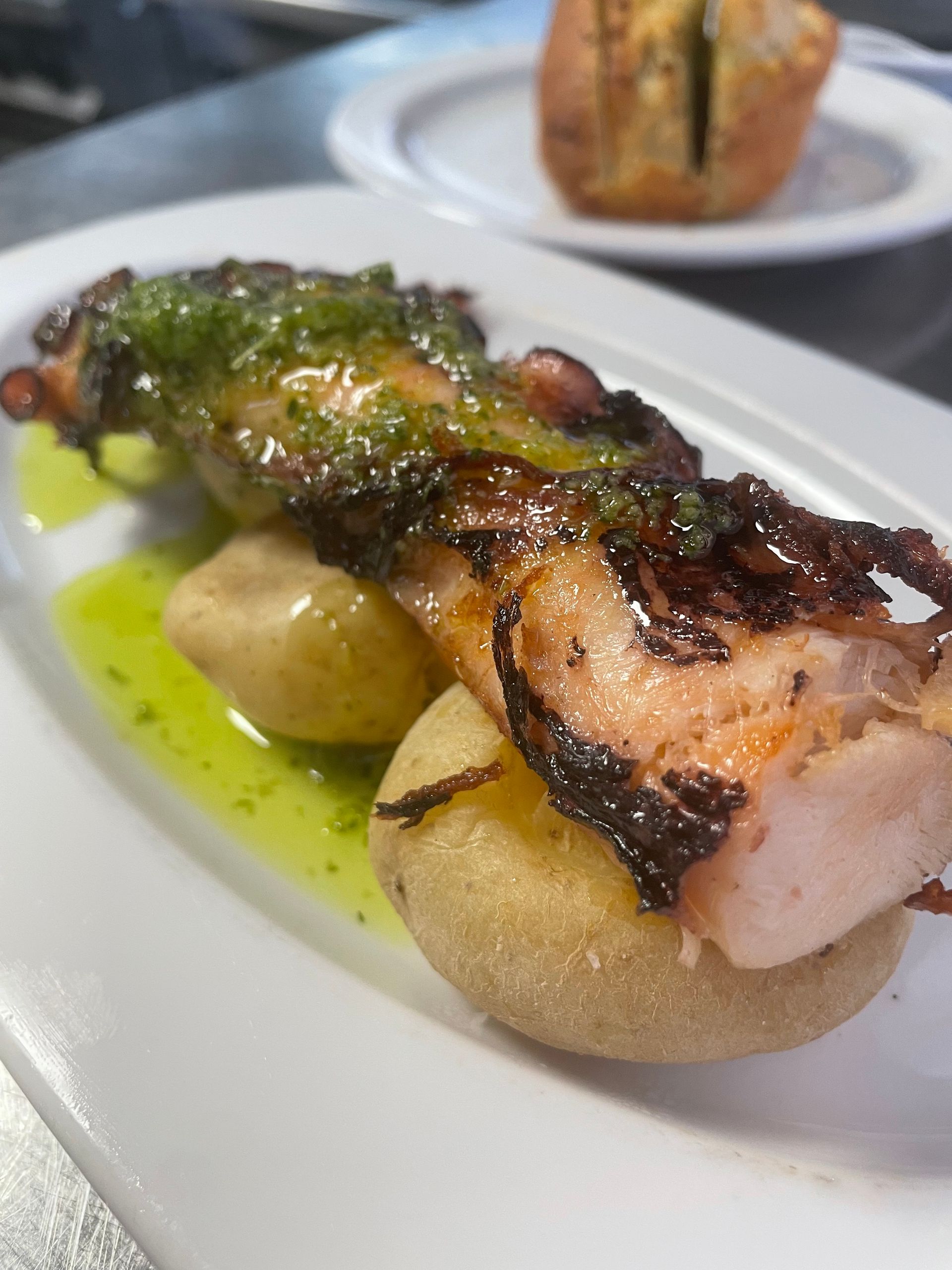 Un plato blanco cubierto con un trozo de carne y patatas.