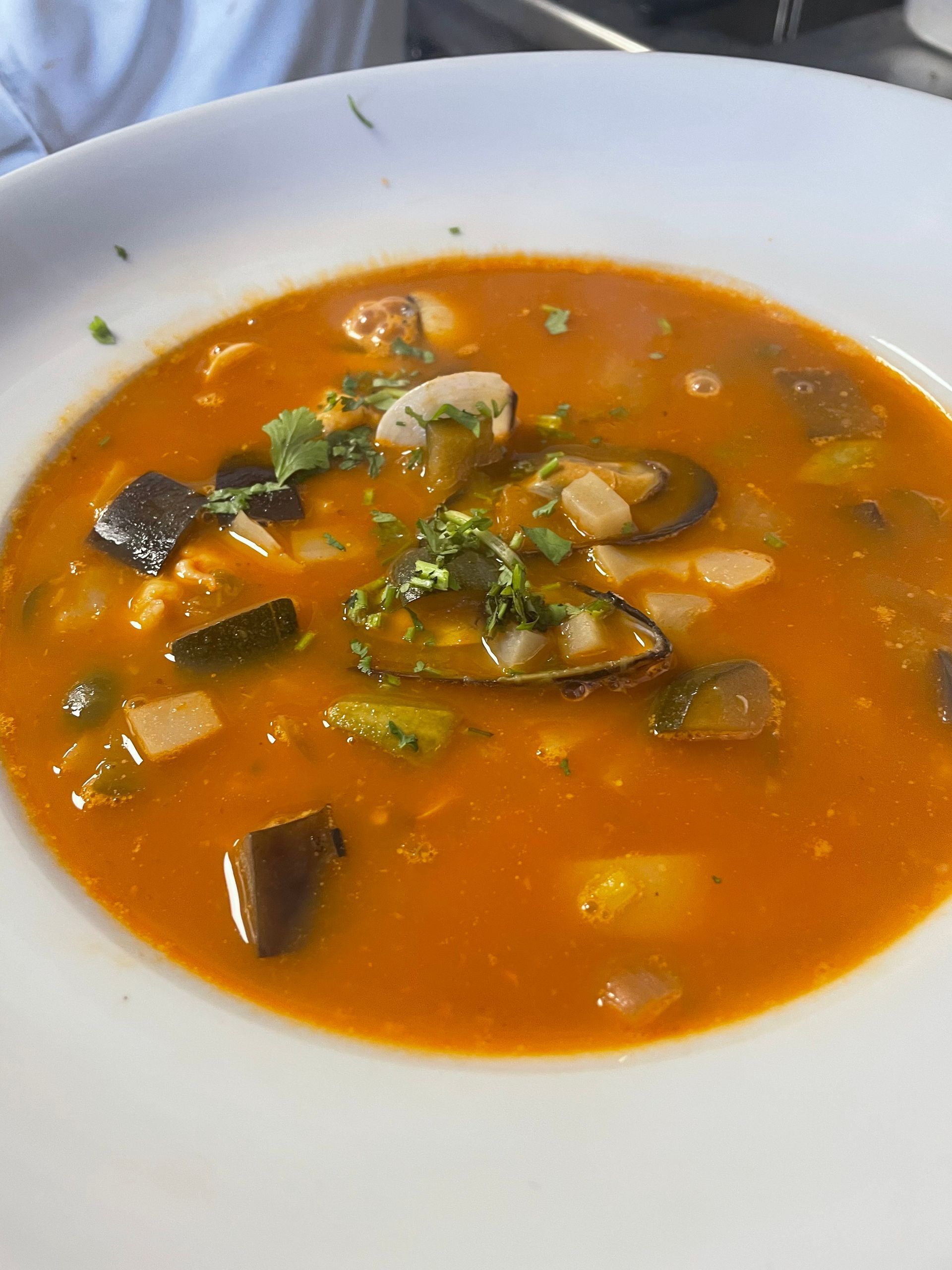 Un primer plano de un tazón de sopa con verduras en una mesa.