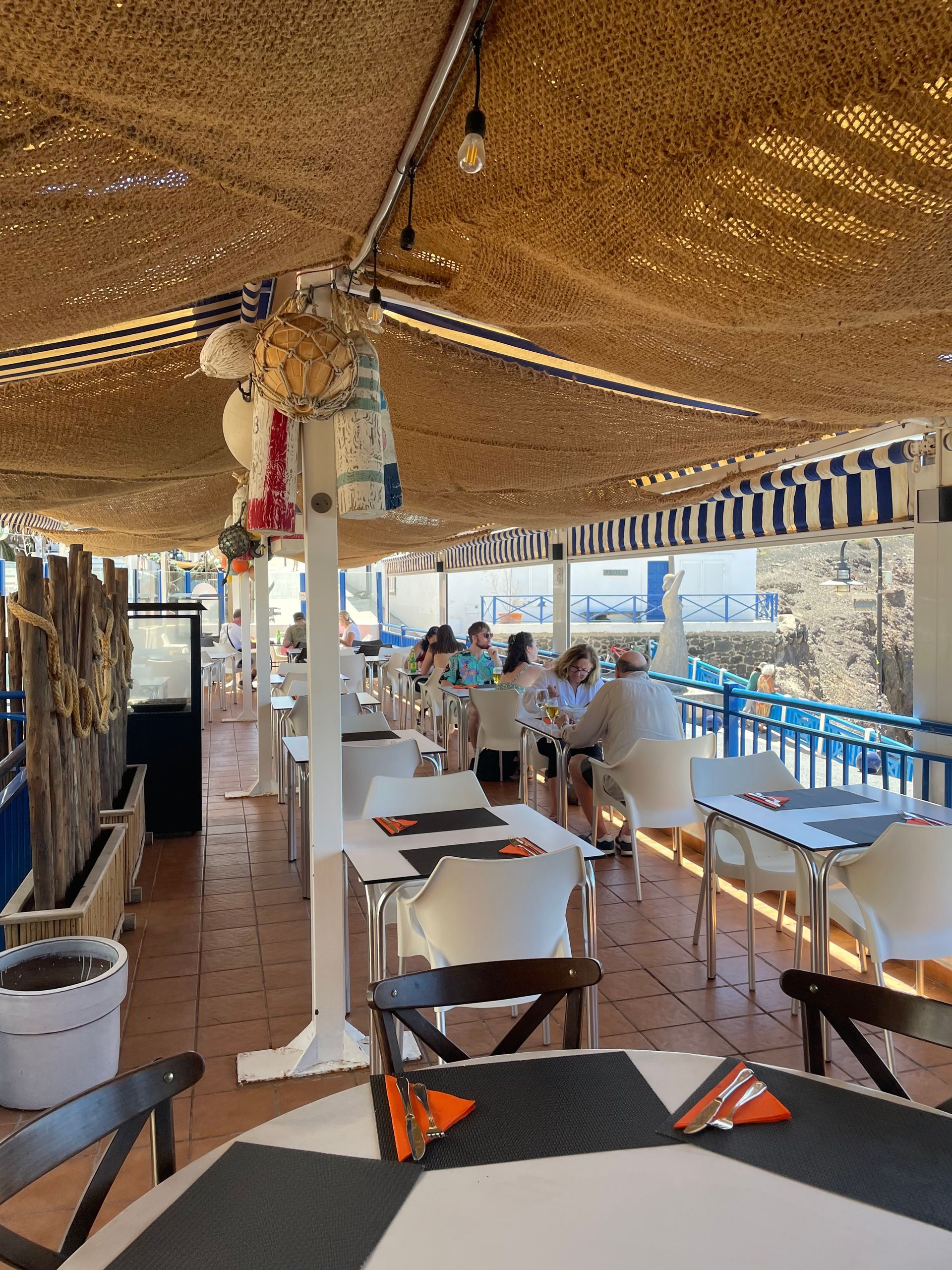 Un grupo de personas están sentadas en mesas en un restaurante.