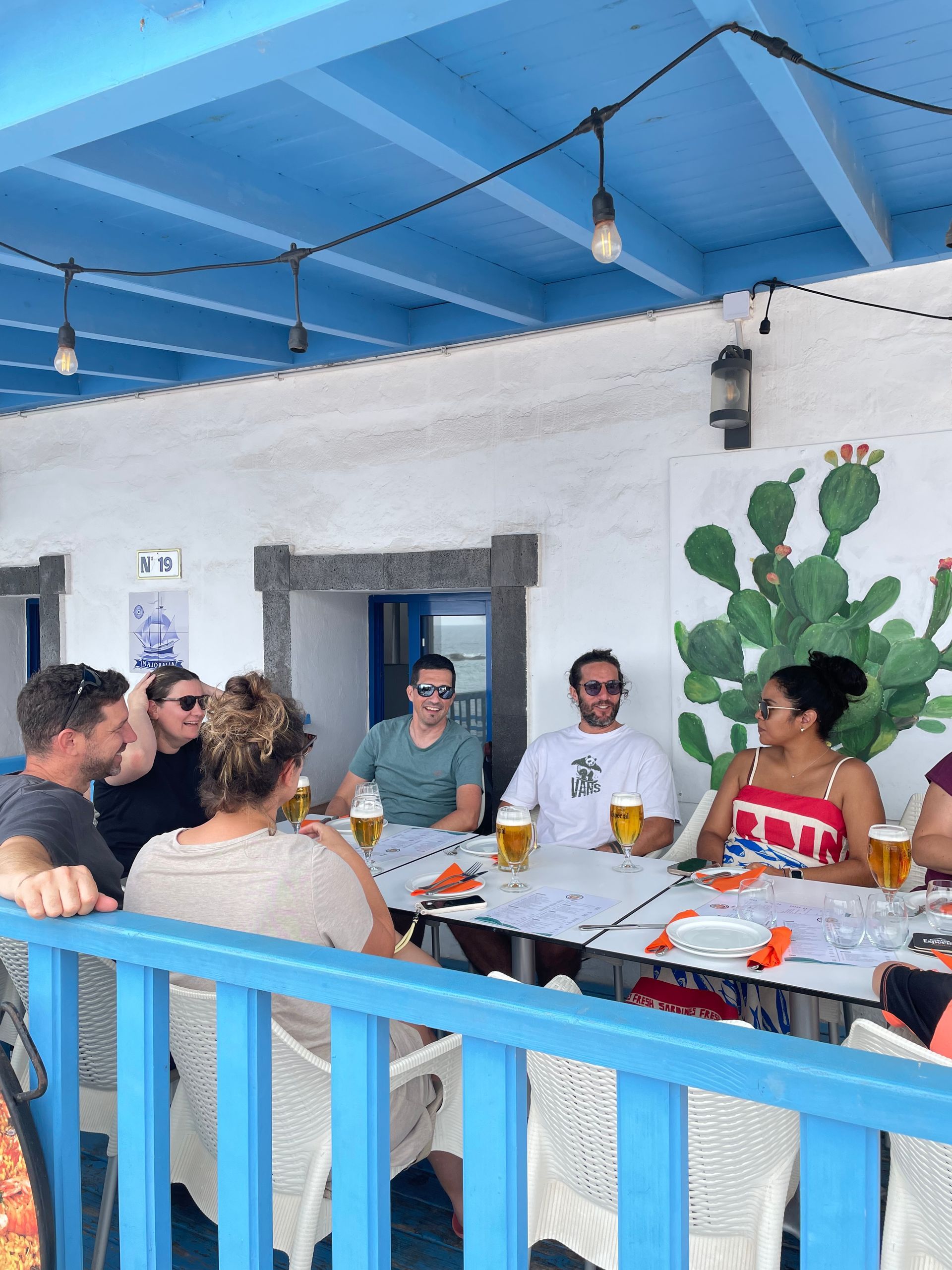 Un grupo de personas están sentadas alrededor de una mesa bebiendo cerveza.