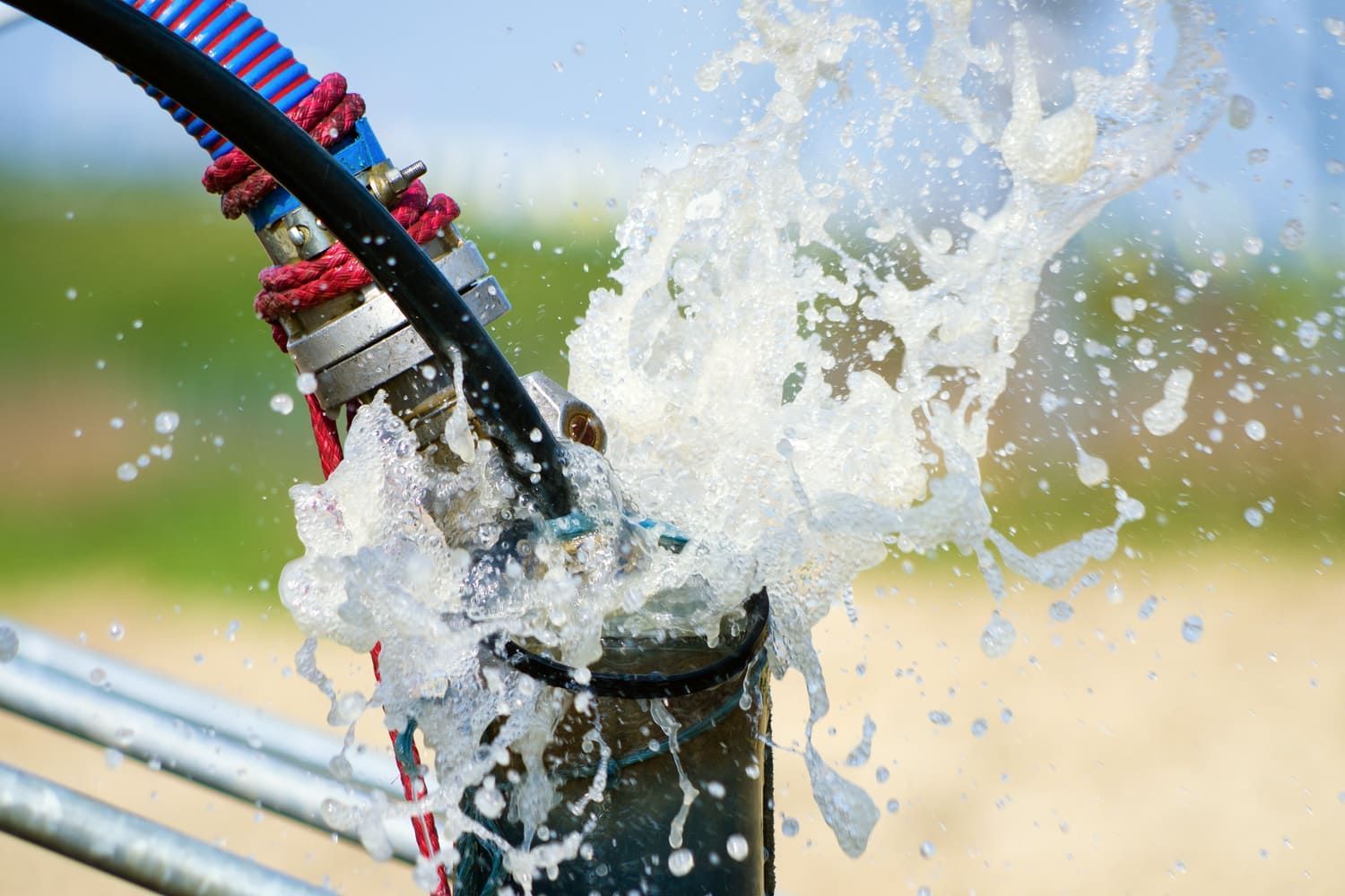 Un primer plano de agua salpicando desde una tubería.