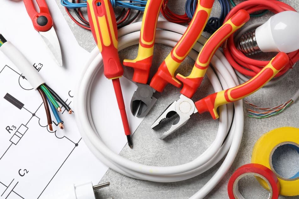 Un montón de herramientas de electricista están sobre una mesa.