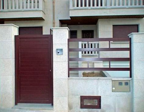 Una casa con una valla y una puerta roja