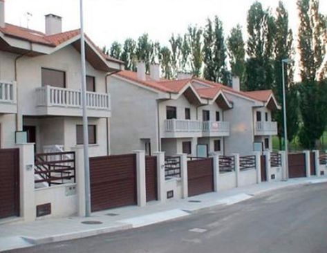 Una hilera de casas con techos rojos y puertas de garaje marrones