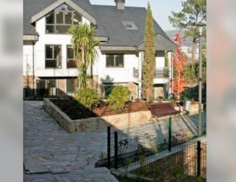 Una gran casa blanca con una valla delante.