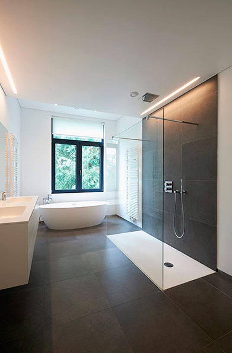 Un baño con bañera y ducha a ras de suelo.