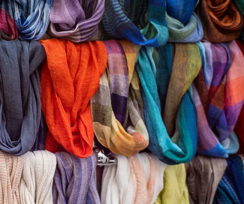 Un montón de bufandas de colores se apilan una encima de otra.