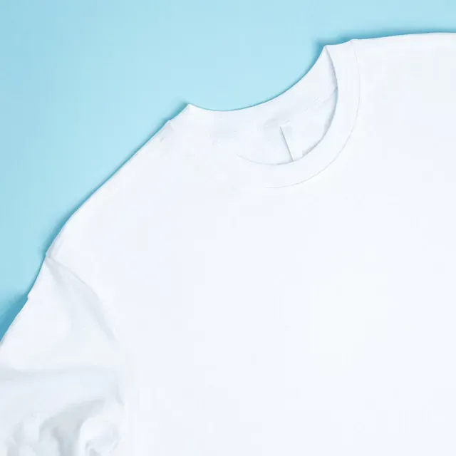 Una camiseta blanca está sobre una superficie azul.