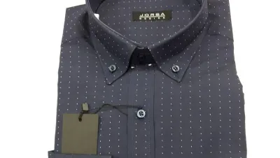 Una camisa azul con lunares blancos tiene una etiqueta adherida.
