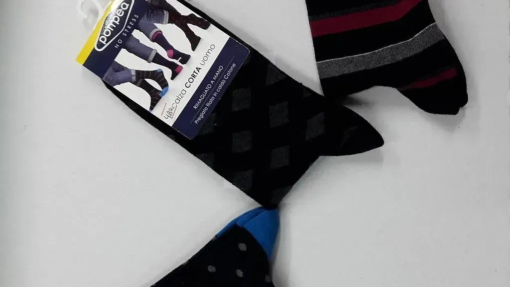 Tres pares de calcetines están sobre una superficie blanca.