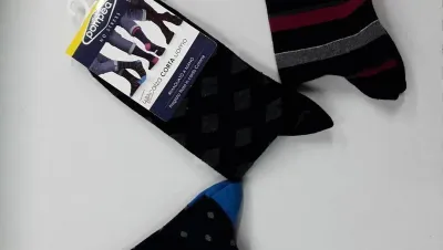 Tres pares de calcetines están sobre una superficie blanca.