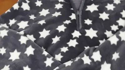 Un primer plano de una manta con estrellas blancas.