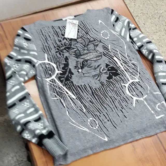 Un suéter gris con un diseño en blanco y negro.
