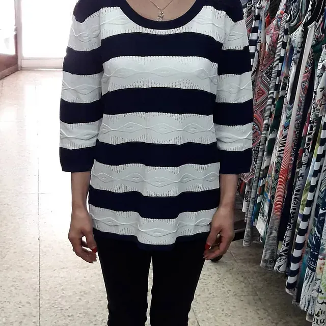 Una mujer que lleva una camisa de rayas blancas y negras