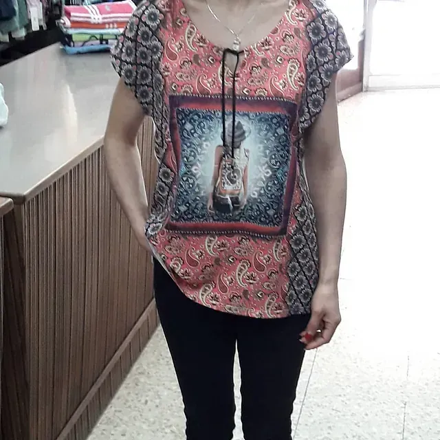 Una mujer que lleva una blusa rosa con la imagen de una mujer.