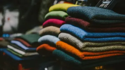 Una pila de suéteres coloridos colocados uno encima del otro en un estante.