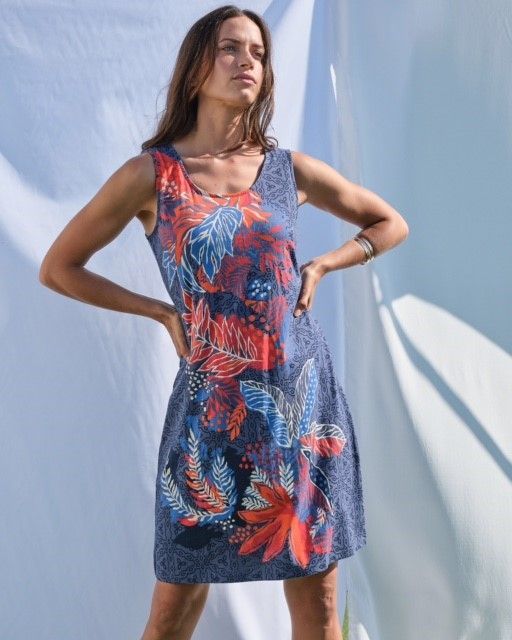 Una mujer que lleva un vestido de verano, sin mangas, los colores son azules y rojos