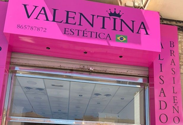 Fachada de peluquería Valentina con señalización negra, escaparates de cristal y servicios listados en español.