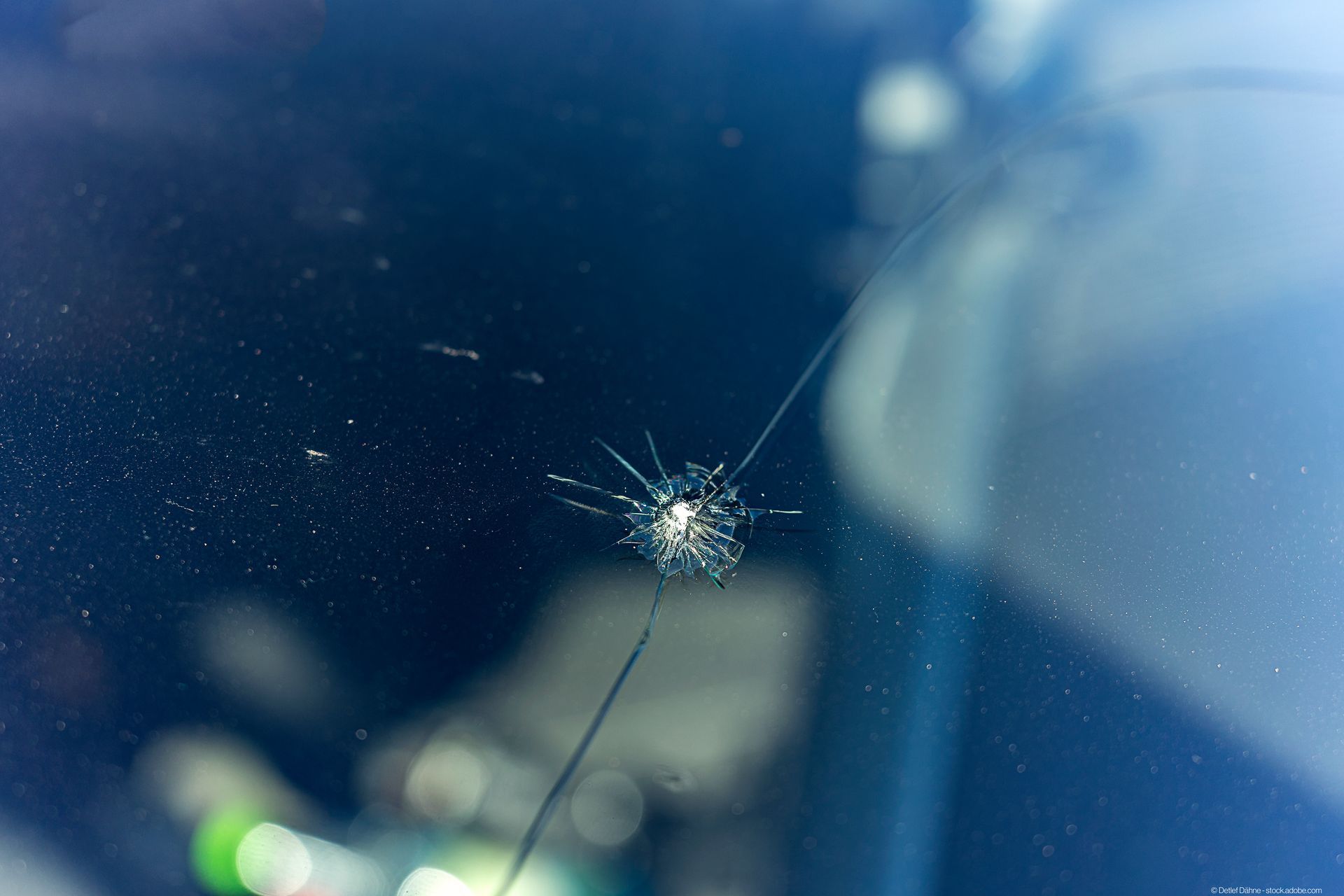 Nahaufnahme einer Windschutzscheibe mit Steinschlag.