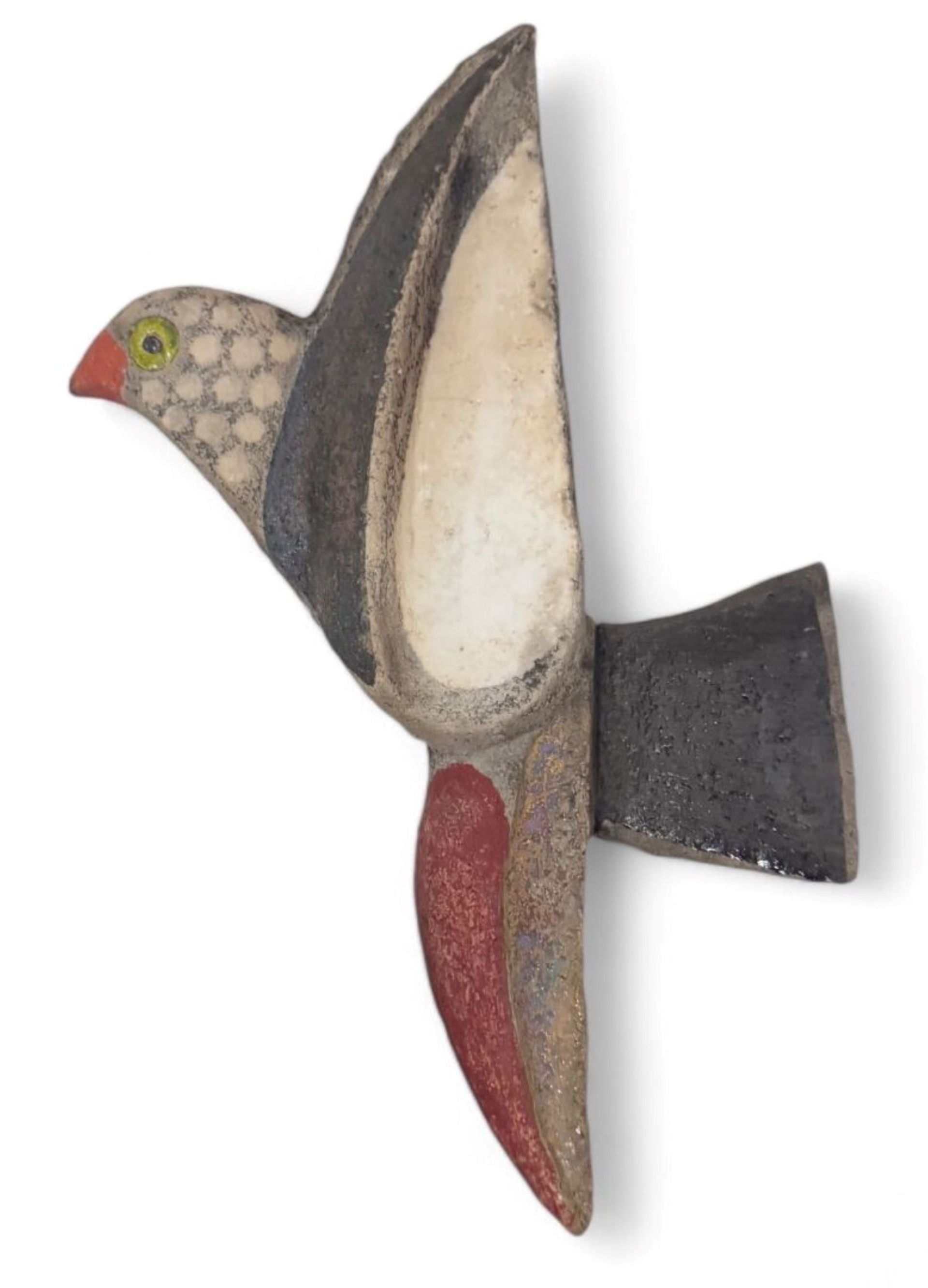 Une sculpture d'oiseau au mur.