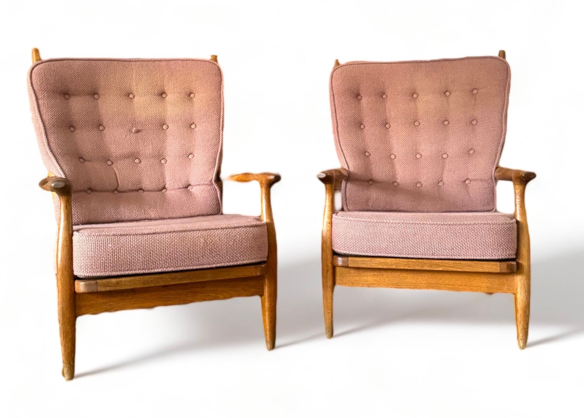 Deux fauteuils modernes du milieu du siècle avec un revêtement à motifs roses et des cadres en bois sur fond blanc.