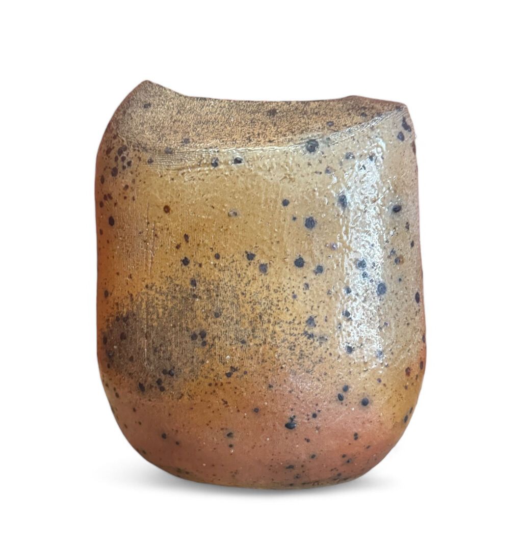 Tasse cylindrique en céramique à glaçure jaune-brun, mouchetée de noir.