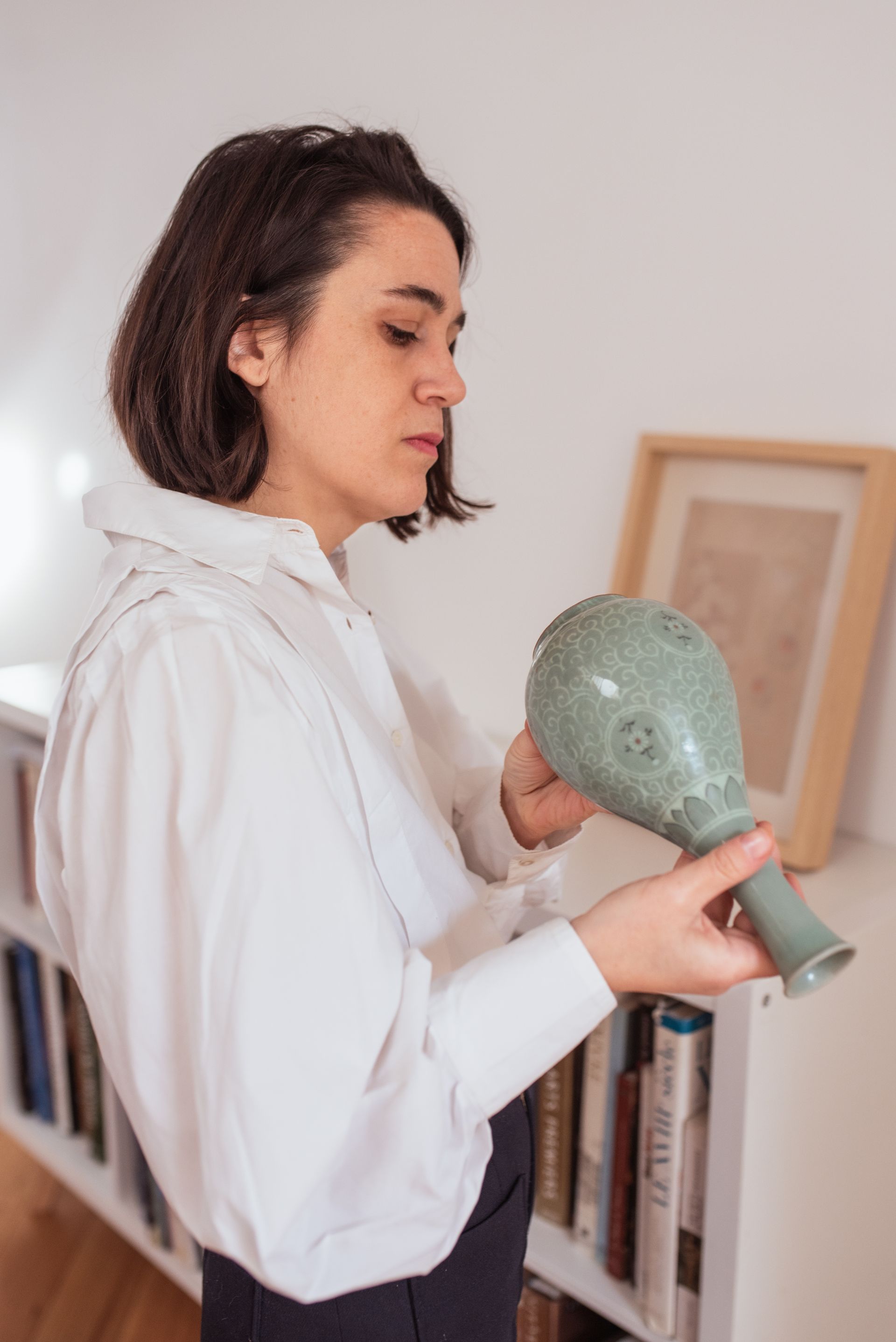 Audrey Sadoul en train de regarder le dessous d'un vase.