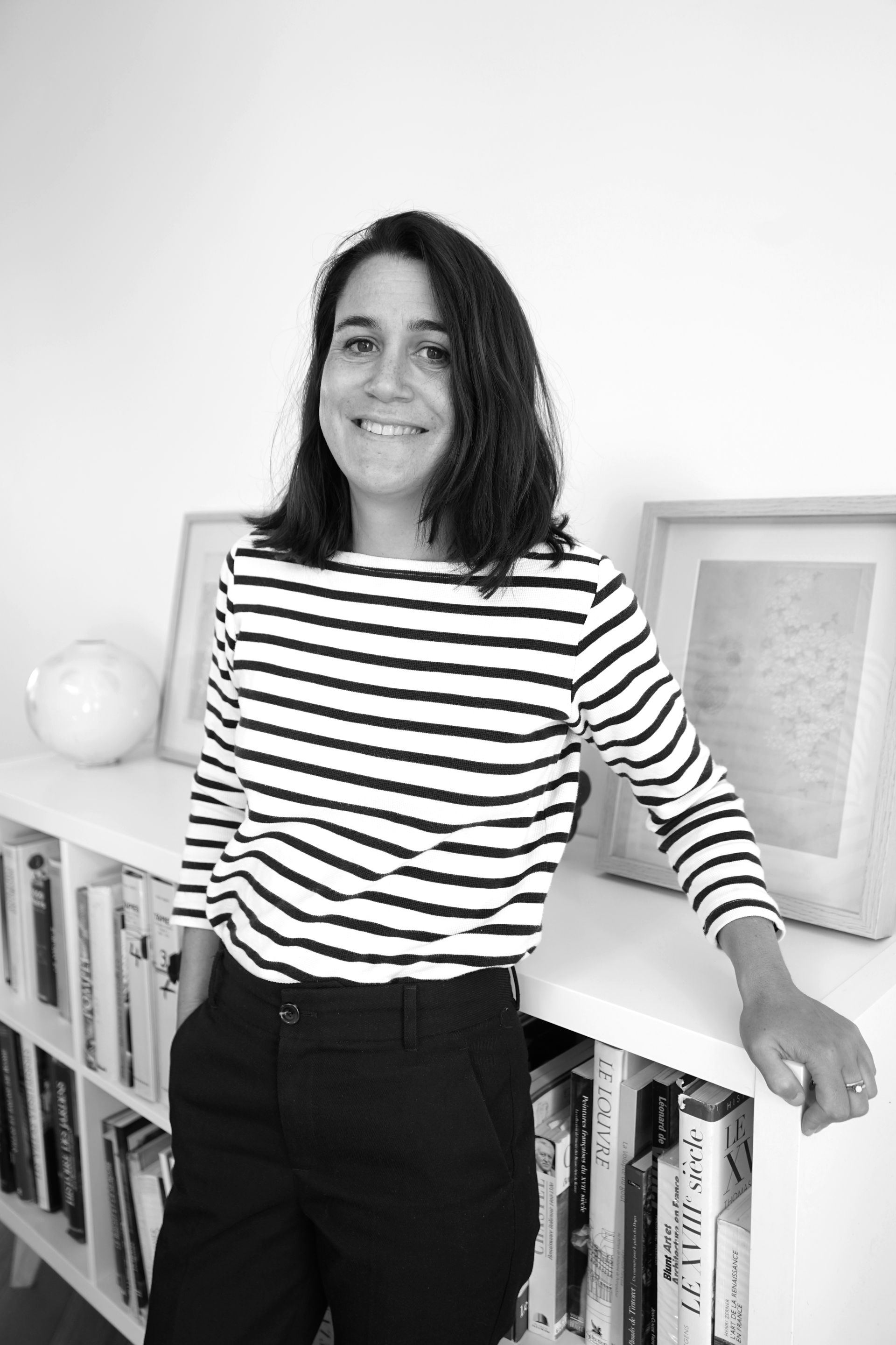 Audrey Sadoul adossée à un meuble contre le mur.