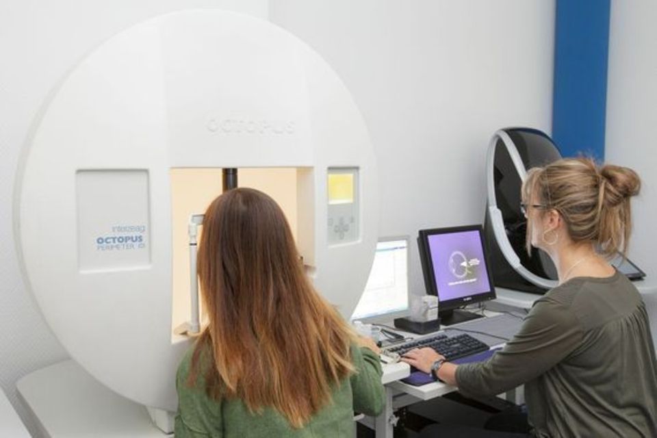 Zwei Frauen sitzen in einem Zimmer vor einem Computer.