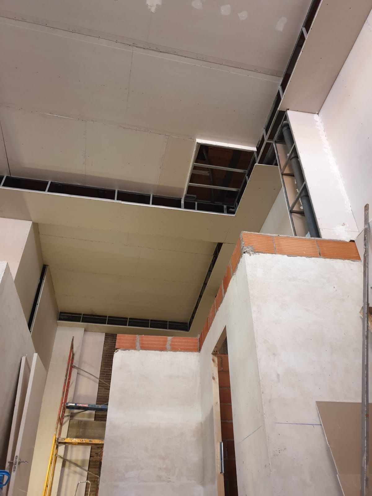Construcción interior: Instalación de paneles de yeso en proceso. 