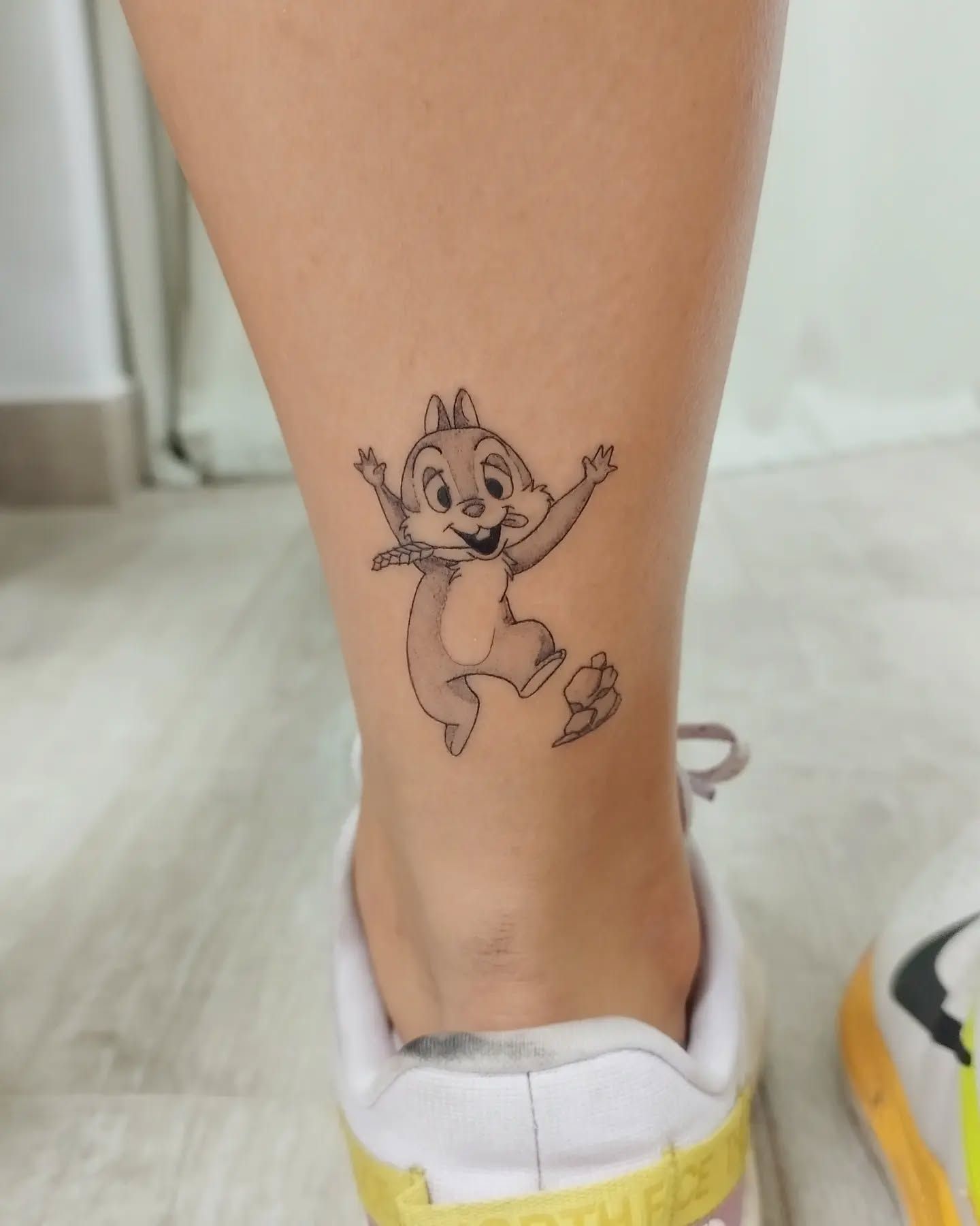 Una persona tiene un tatuaje de una ardilla en el tobillo.