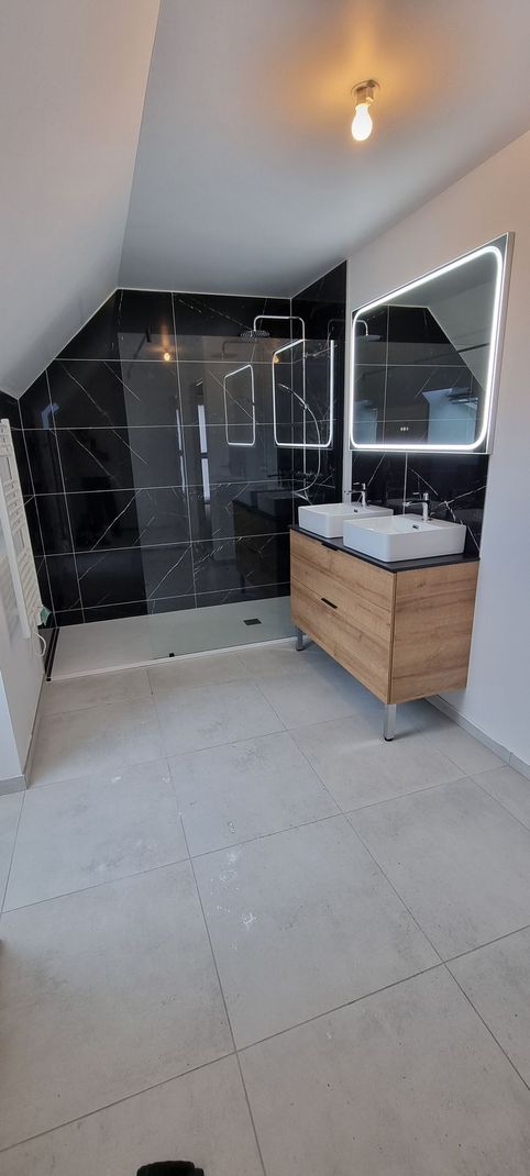 Une salle de bains avec une douche de couleur noire