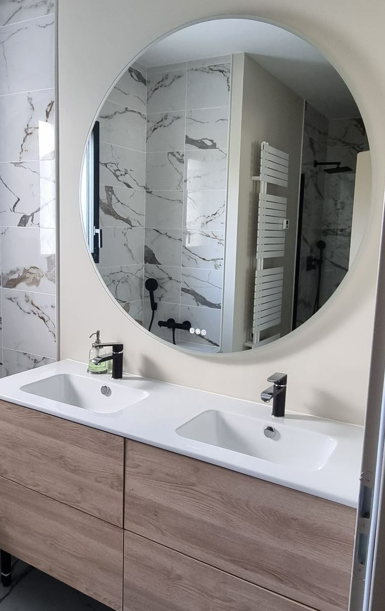 Deux lavabos avec un miroir rond