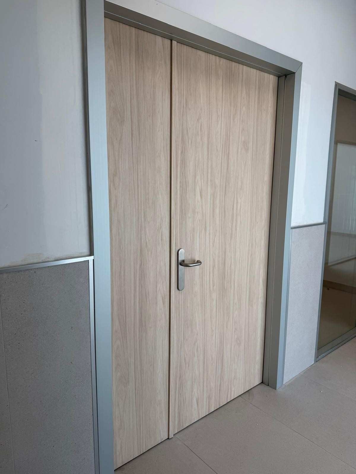 Puertas dobles de madera con tirador plateado en un pasillo.