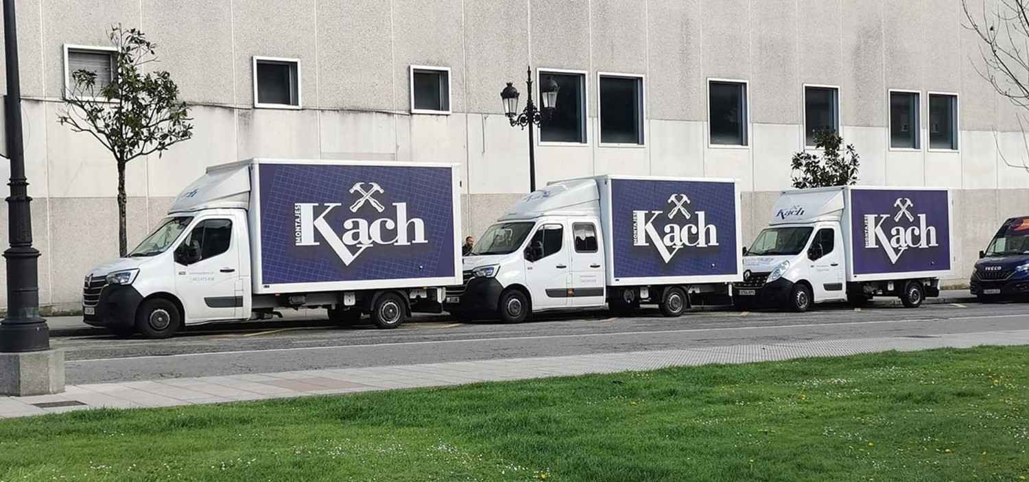 Cuatro furgonetas blancas con el logotipo azul de 