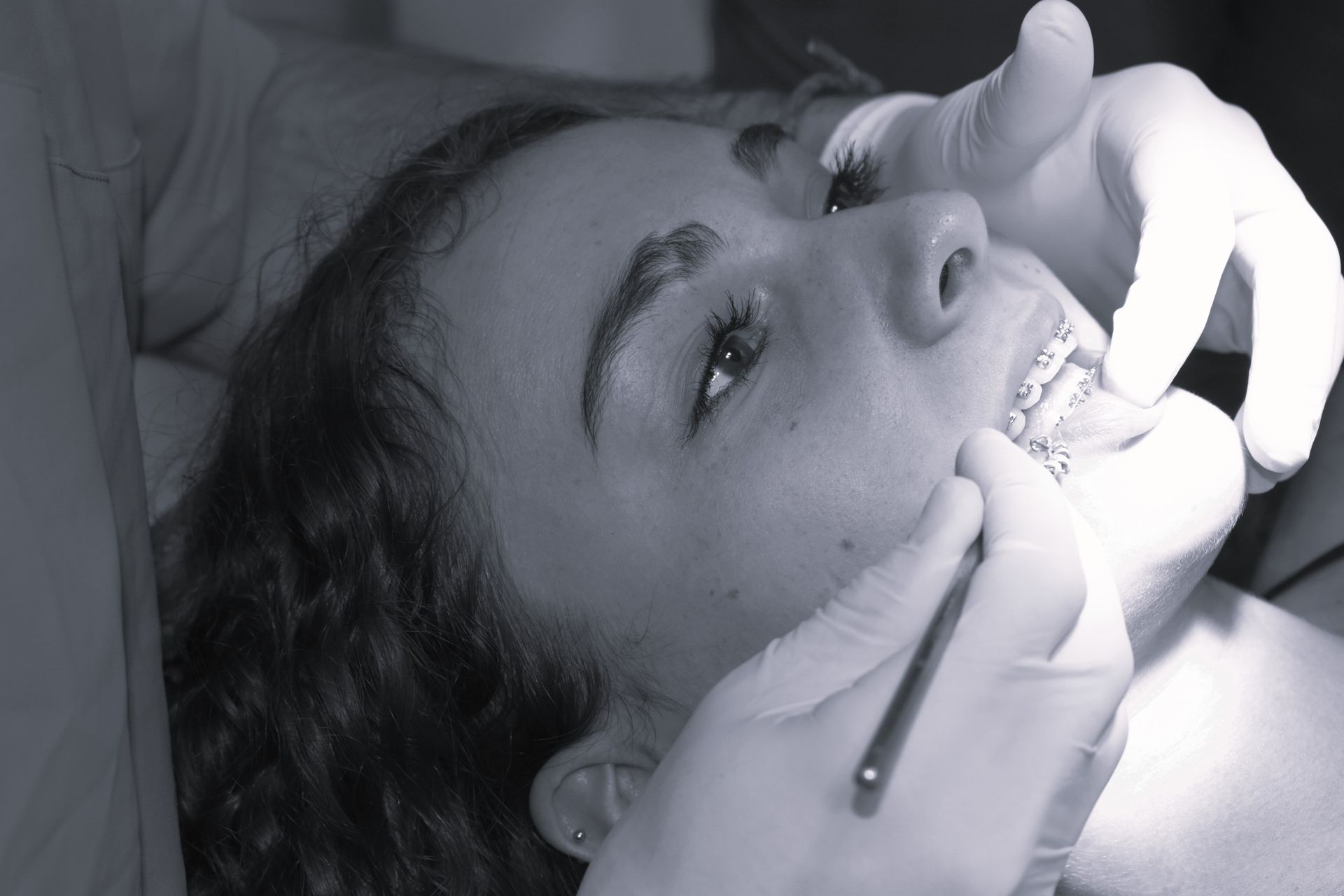 Una mujer se está haciendo examinar los dientes por un dentista.