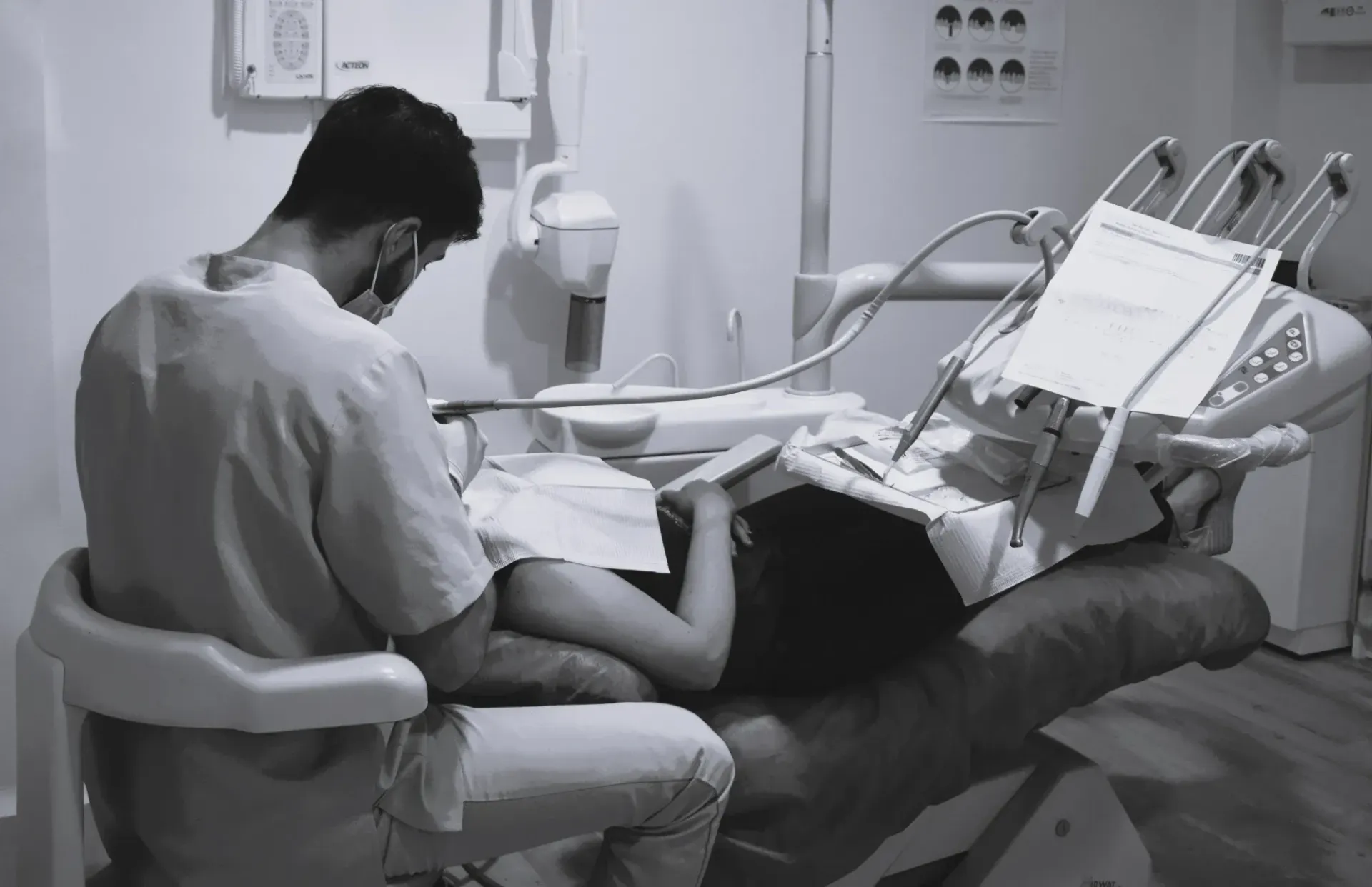 Un dentista está trabajando con un paciente en una silla dental.