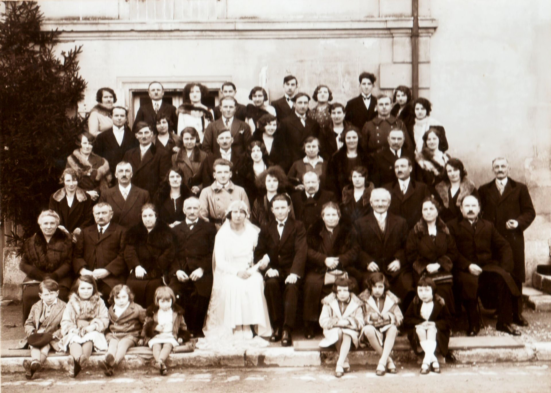Des mains d'enfant jouent avec des figurines en bois sur une table en bois. D'autres figurines en pierre sont également présentes.