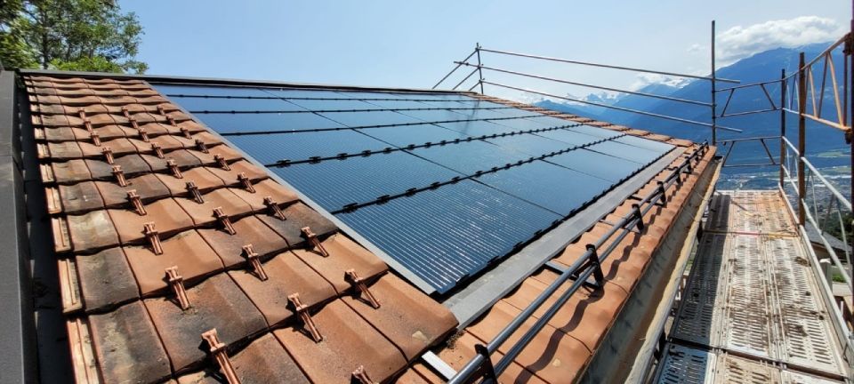 Panneaux solaires installés sur un toit de tuiles, avec échafaudages.