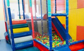 Una piscina de pelotas colorida con un tobogán y escaleras.