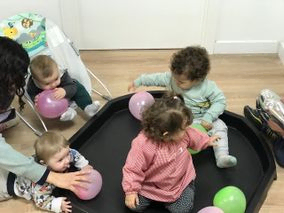 Un grupo de niños está jugando con globos en una habitación.