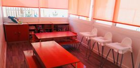 Una habitación con mesas y sillas y una ventana.