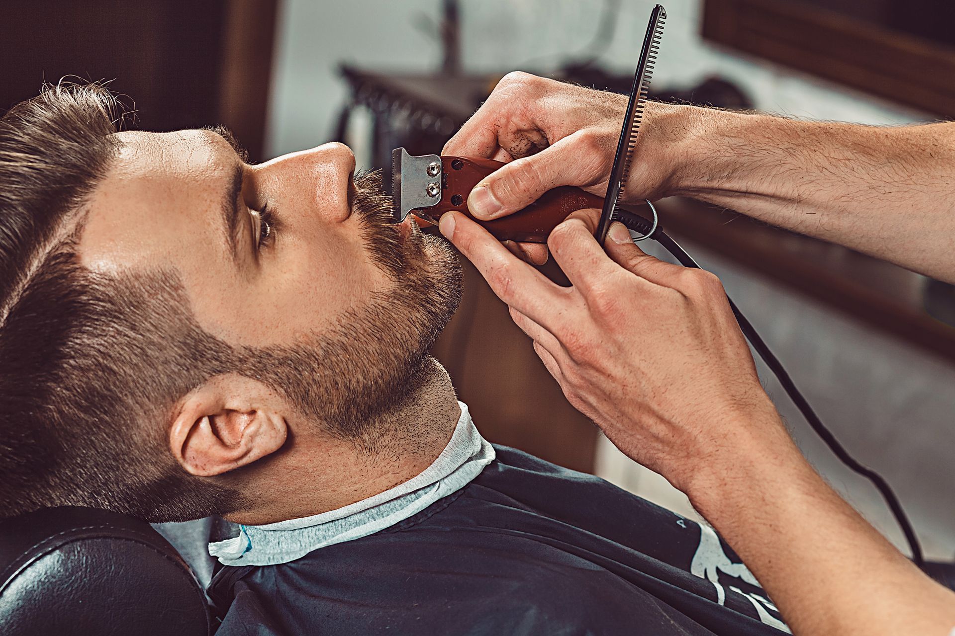 Un hombre se está recortando la barba en una barbería.