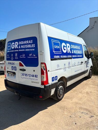 Camionnette blanche avec logos bleus pour GR Débarras & Meubles, garée à l'extérieur par une journée ensoleillée.