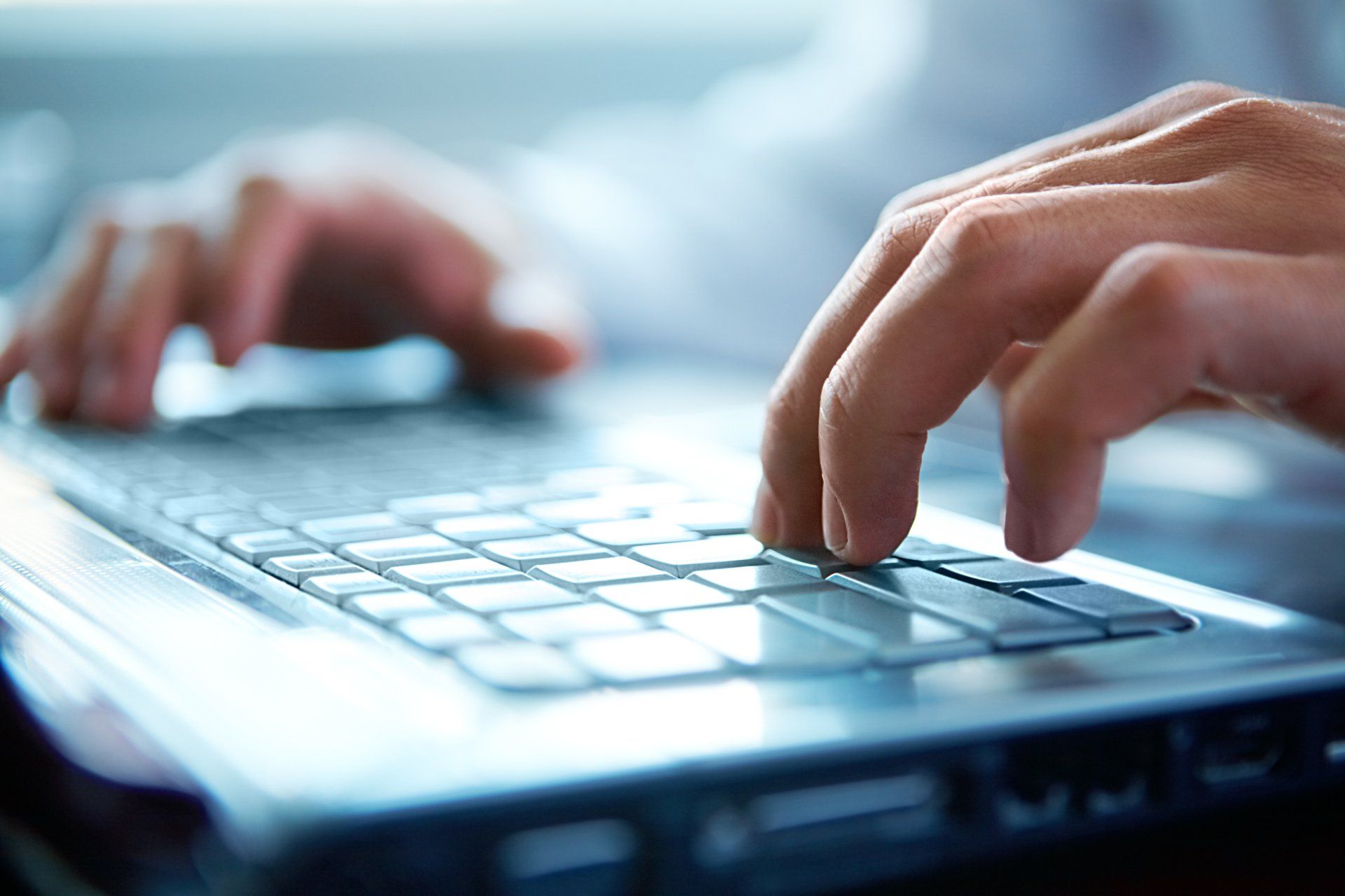 Vue sur un clavier d'ordinateur avec des mains en train d'écrire