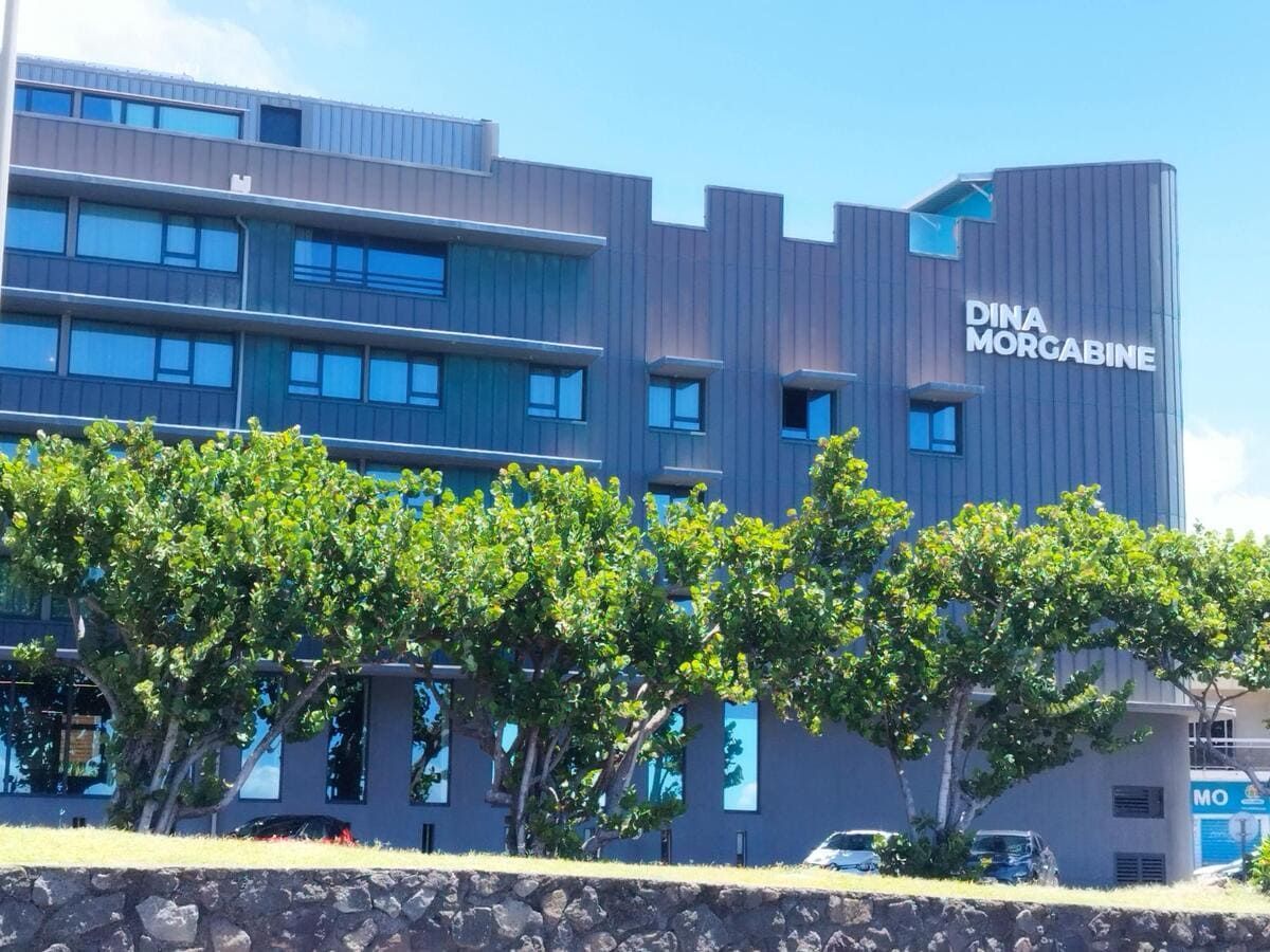 Grand batiment marron avec arbres devant