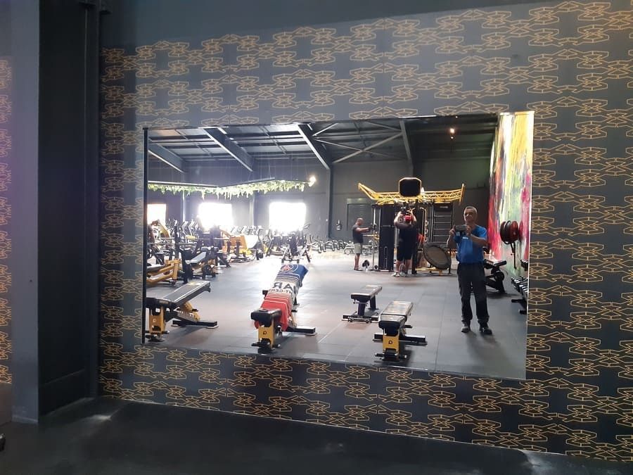 Salle de sport avec grand miroir et machines de sport