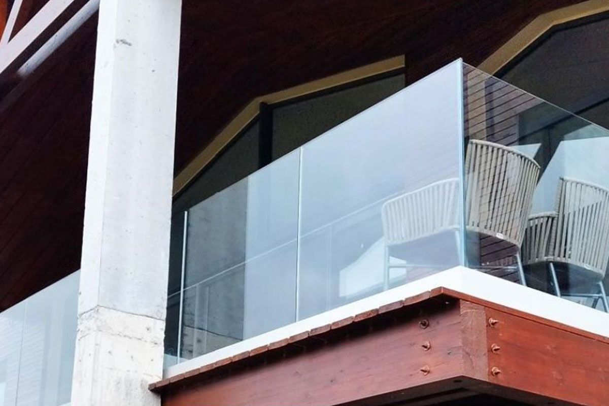 Contre-plongée du garde-corps en verre d'une terrasse en bois brun ocre