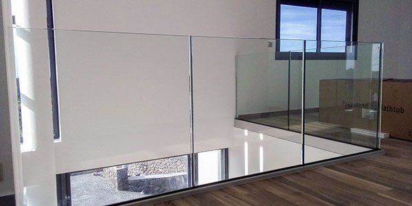 Des cartons autour d'un garde-corps en verre au premier étage