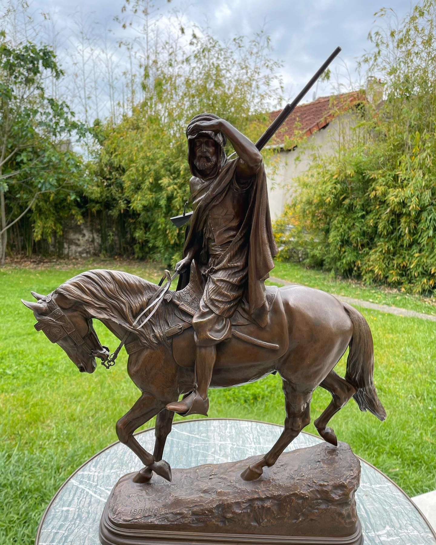 Statue équestre en bronze représentant un homme regardant au loin, tenant une lance. Le cheval s'avance, sur un piédestal.